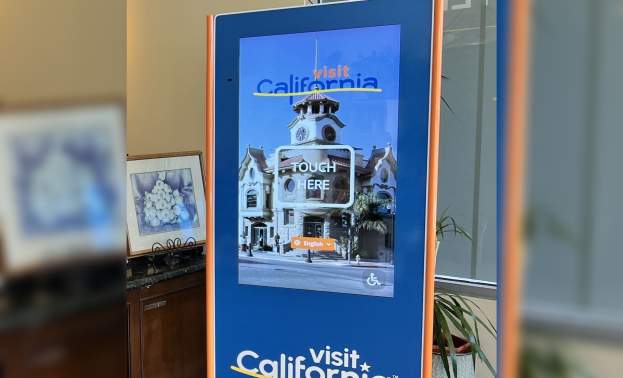 A tall interactive touchscreen kiosk stands inside the California Welcome Center, Gilroy, an easy tool to assist trip planning and exploring.