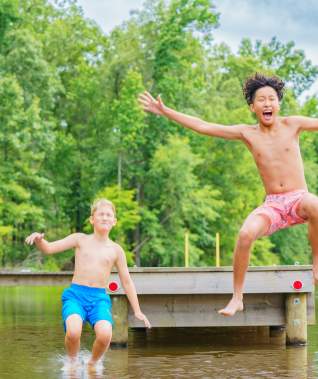 Two Boys Jumping Off a Pier at Cypress Black Bayou