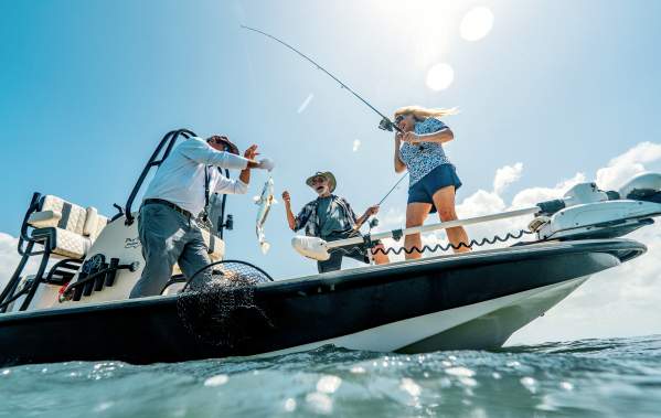 Anglers reeling in a catch while bay fishing on a guided South Padre Island fishing charter