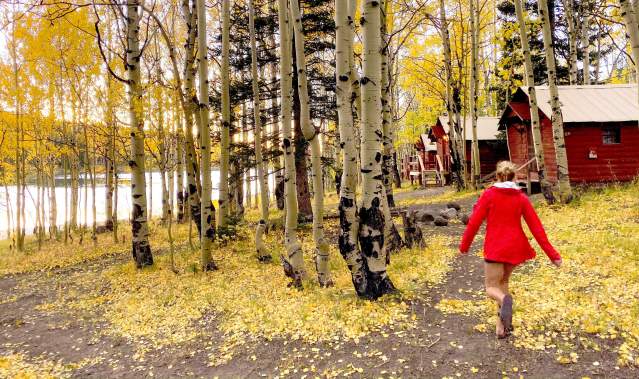 Woman Walking towards a Cabin on the Grand Mesa in a Red Coat