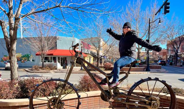 Woman Sitting on Large Bike Sculpture in Downtown Grand Junction