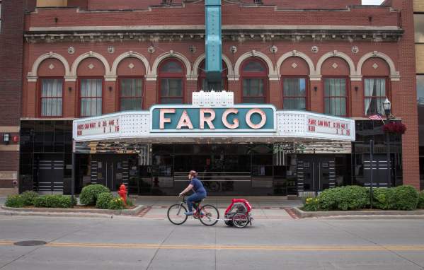 someone biking in front of fargo theatre at streets alive event