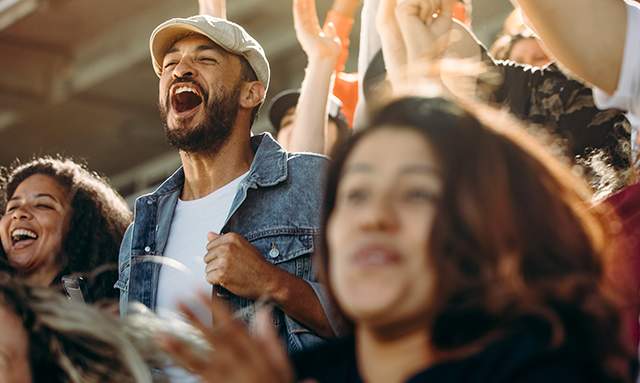 A group of people cheering in a stadium