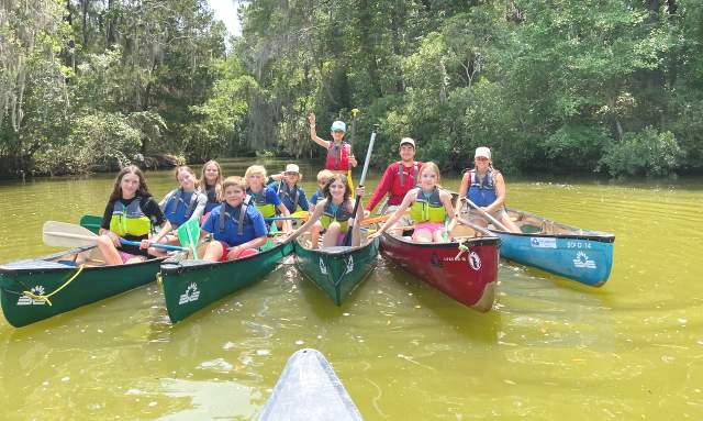Kids at summer camp in canoes.
