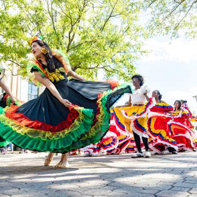 Colorful dancers performing traditional cultural dances during the Parade of Nations during the International Folk Festival in downtown Fayetteville, NC.