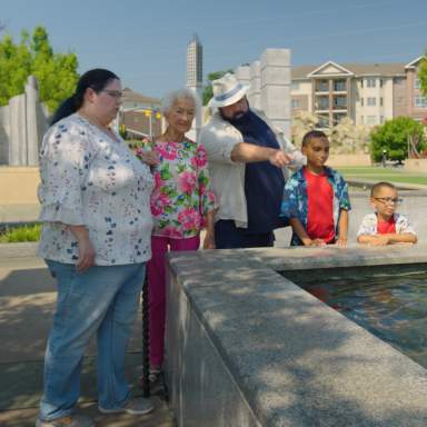 Multi-generational family gathered around the reflection pool in Fayetteville's Veterans' Park