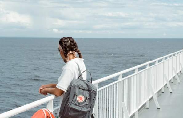 A women on a ferry looking over the railing.