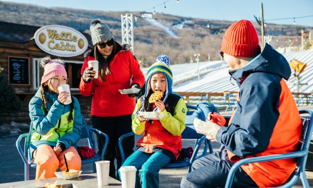 A family enjoys waffles by the ski slopes at Camelback Mountain.