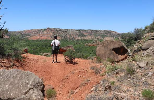 man overlooking palo duro canyon from a trail