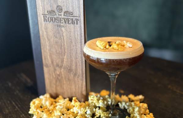 Espresso martini garnished with popcorn and coffee beans, surrounded by popcorn at The Roosevelt Room.