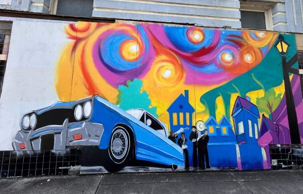 Blue car in front of colorful background