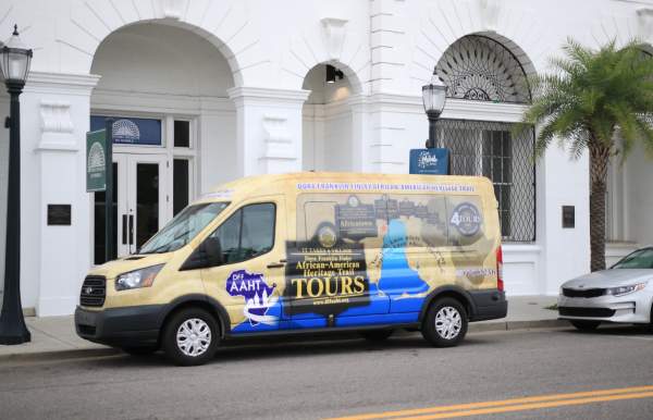colorful passenger van parked in front of white building