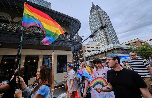 Group of people in the street with rainbow fan and a rainbow flag