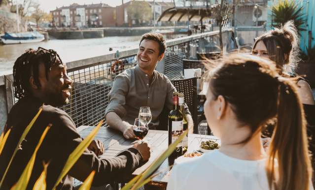Friends drinking wine on the terrace at Harbour House