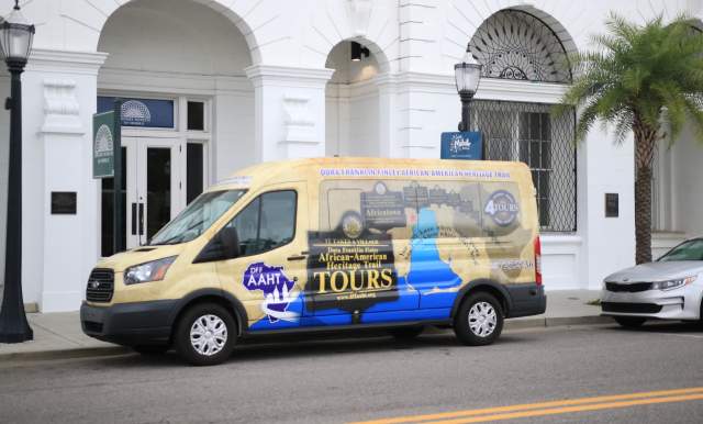 colorful passenger van parked in front of white building