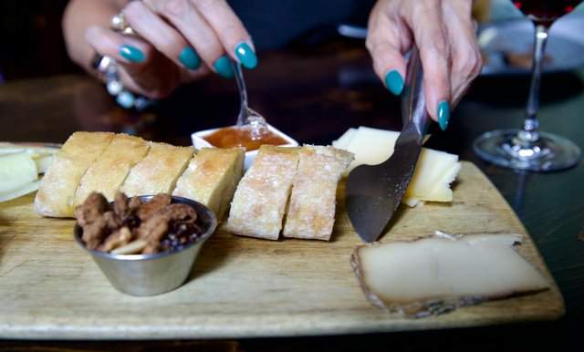 Charcuterie board with bread, nuts, cheese and preserves