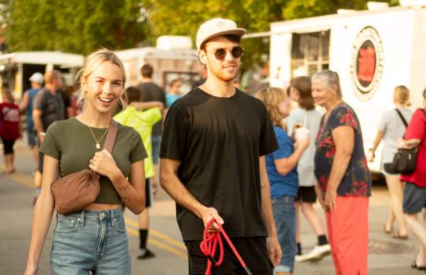couple with dog and food trucks