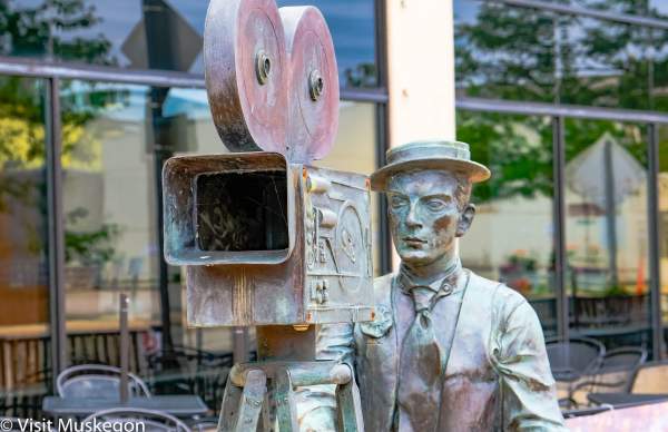 bronze statue of silent film star buster keaton with movie camera
