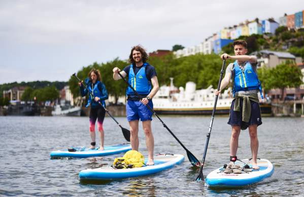 People stand up paddleboarding in Bristol harbour
