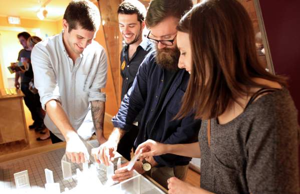 Four adults interacting with a exhibit at the Hands-On Museum
