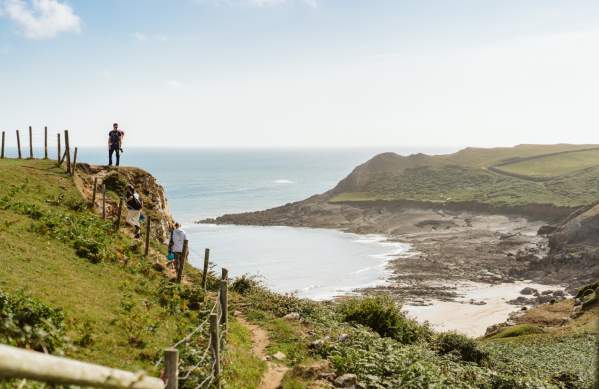 Figures on the coast path with climbing gear.