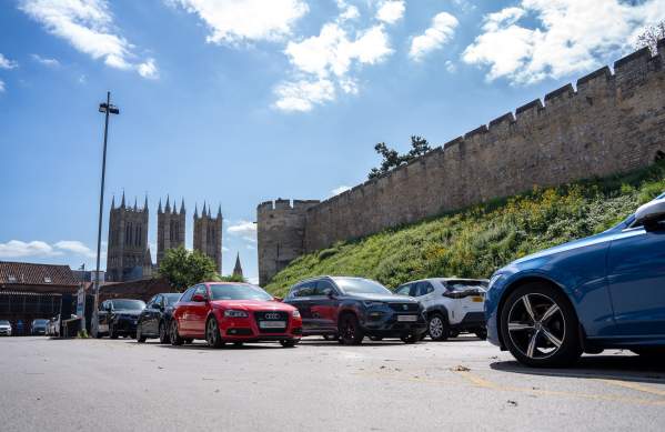 Castle Hill car park with cars in foreground and castle in background on sunny day