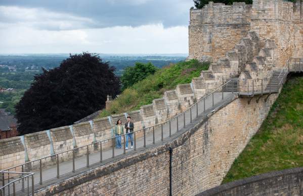 A couple walking along the Medieval Wall Walk at Lincoln Castle