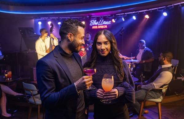 Stylish couple holding drinks at Blue Llama Jazz Club
