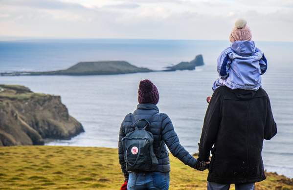 A man and a woman looking out at Worm's head. The man has a child on his shoulder.