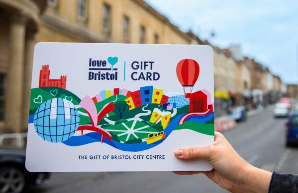 Hand holding a Love Bristol Gift Card shopping voucher in Park Street, central Bristol - credit Bristol BIDs