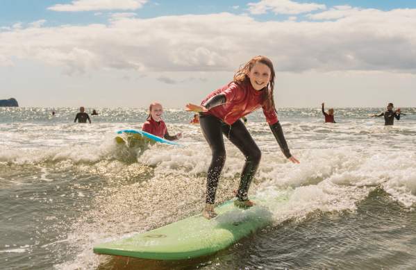 young girls surfing in rhossili bay