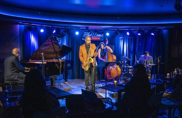 Band on stage, Man playing saxophone, woman on standup bass