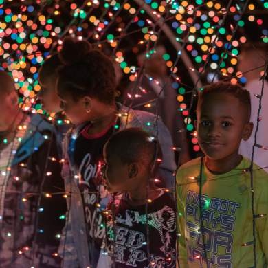 kids looking through a Christmas light display