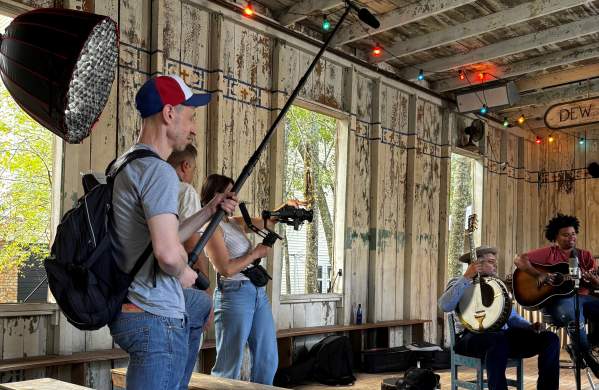 A film crew records local musicians playing instruments inside the Dew Drop Jazz and Social Hall in Mandeville.