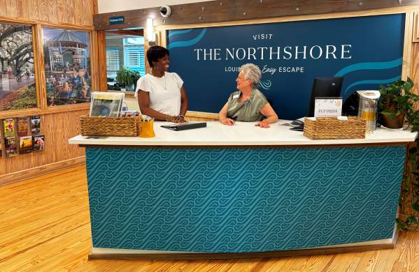 Zondra White Jones and Annette Shurtz welcoming visitors at the front desk inside the Visit The Northshore Visitor Center in Mandeville, Louisiana