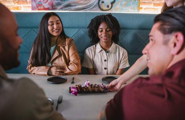 Food plate being delivered to a table of guests