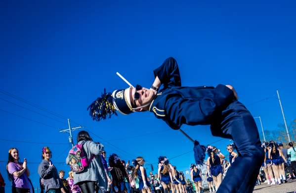 A high school band drum major in a backbend before the Krewe of Dionysus Mardi Gras parade in Slidell.
