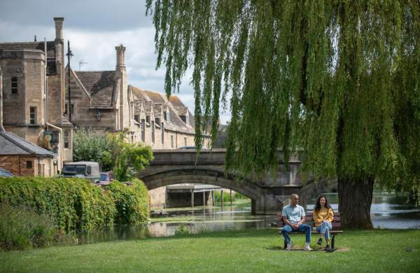 Two people sat on park bench in Stamford town centre