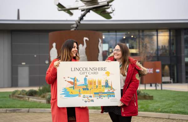 2 lovely people holding a giant lincolnshire gift card at the International Bomber Command Centre