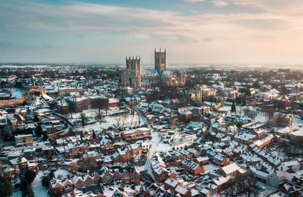 An aerial shot of Lincoln covered in snow, with Lincoln Cathedral in the distance