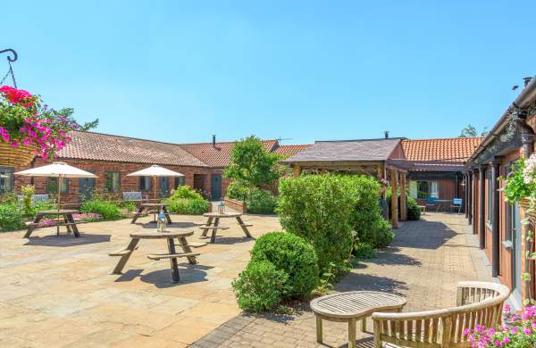 Holiday cottages courtyard area with plants and picnic tables