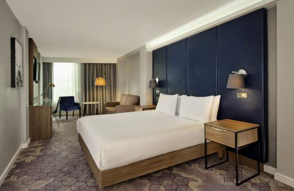 A bright hotel room with large bed.