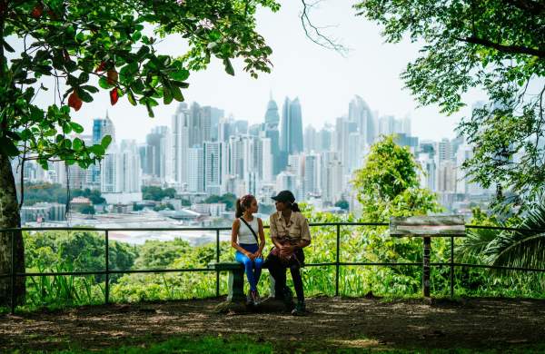 Turistas descansando en un mirador del Parque Natural Metropolitano con el skyline de Ciudad de Panamá al fondo