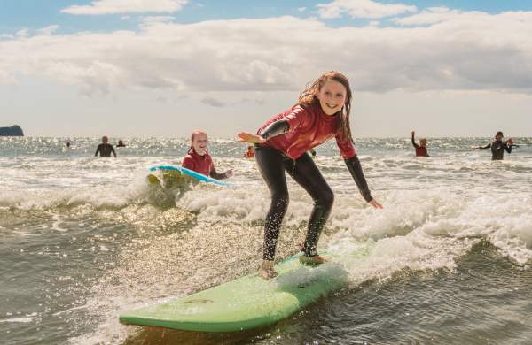 young girls surfing in rhossili bay