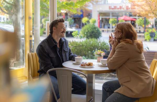 Couple chatting in a cafe window seat