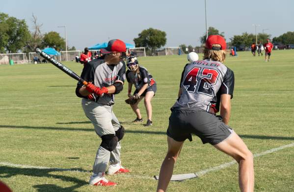a few men on a baseball field hitting the ball