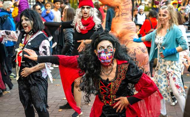 Zombie dressed people start in a flash mob dance.