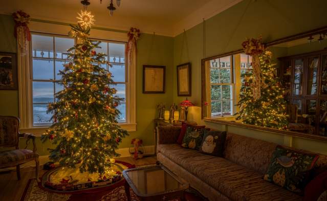 A lighted Christmas tree adorns a living room decorated for Christmas at the Heceta Head Bed and Breakfast.
