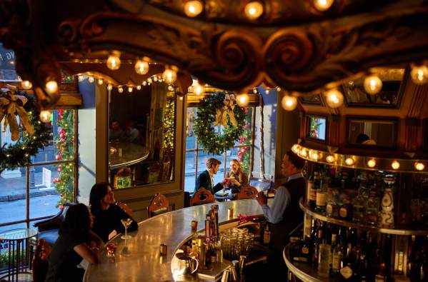A couple enjoys holiday cocktails in the festive environment of the Carousel Bar in Hotel Monteleone.