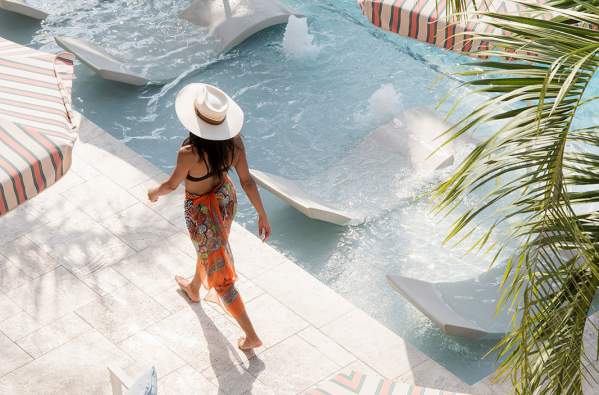 A woman walks by the pool at the Garden District Hotel in New Orleans